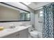 Bathroom featuring a double sink vanity, shower and bathtub combination with blue flower curtain at 10125 Cherry Creek Ln, Port Richey, FL 34668