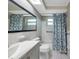 Bathroom featuring a double sink vanity and a shower and bathtub combination with a decorative blue flower curtain at 10125 Cherry Creek Ln, Port Richey, FL 34668