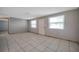 Neutral living room with tile floors and access to additional space at 10125 Cherry Creek Ln, Port Richey, FL 34668