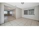 Open layout room featuring tile flooring, a window and access to the kitchen at 10125 Cherry Creek Ln, Port Richey, FL 34668
