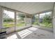 Enclosed sunroom featuring multiple windows providing natural light and views of the surrounding landscape at 10125 Cherry Creek Ln, Port Richey, FL 34668