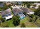 Aerial view of a fenced backyard featuring a screened-in pool, lush green lawn, and mature trees at 10216 Summer Azure Dr, Riverview, FL 33578