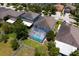 Aerial view of a fenced backyard featuring a screened-in pool, lush green lawn, and mature trees at 10216 Summer Azure Dr, Riverview, FL 33578