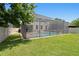 Grassy backyard with screened-in pool, brick paver deck, and view of the home at 10216 Summer Azure Dr, Riverview, FL 33578