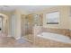 A luxurious bathroom with a glass-enclosed shower and separate soaking tub at 10216 Summer Azure Dr, Riverview, FL 33578