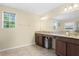 A spacious bathroom with double sinks, granite countertops, and tile floors at 10216 Summer Azure Dr, Riverview, FL 33578