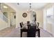 Formal dining area with contemporary chandelier, next to staircase, and a view of the kitchen at 10216 Summer Azure Dr, Riverview, FL 33578