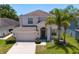 Attractive two-story home featuring a two-car garage, lush lawn, and mature trees at 10216 Summer Azure Dr, Riverview, FL 33578