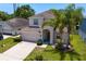 Charming two-story home with well-manicured lawn, two palm trees, and an attached two-car garage at 10216 Summer Azure Dr, Riverview, FL 33578