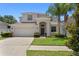 Charming two-story home features a well-manicured lawn, two-car garage and mature palm tree at 10216 Summer Azure Dr, Riverview, FL 33578