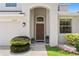 The front entryway features manicured shrubs, a two-car garage, and a brown wooden door at 10216 Summer Azure Dr, Riverview, FL 33578