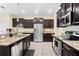 Updated kitchen with dark wood cabinets, stainless steel appliances, and granite countertops at 10216 Summer Azure Dr, Riverview, FL 33578