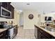 Well-lit kitchen showcasing stainless steel appliances, granite countertops, and tile flooring at 10216 Summer Azure Dr, Riverview, FL 33578