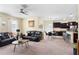Open living room with dark leather furniture flows into the kitchen, with tile and carpeted floors at 10216 Summer Azure Dr, Riverview, FL 33578