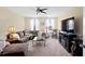 Bright living room with large sectional sofa, fan and an entertainment center at 10216 Summer Azure Dr, Riverview, FL 33578