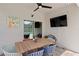 Covered patio with outdoor dining table, ceiling fan, TV, and view to backyard at 10216 Summer Azure Dr, Riverview, FL 33578