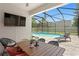 Covered patio with outdoor dining table and view to a screened-in pool and backyard at 10216 Summer Azure Dr, Riverview, FL 33578