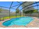 Screened-in pool with brick paver decking and view to grass backyard and houses at 10216 Summer Azure Dr, Riverview, FL 33578