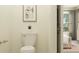 Powder room showcasing a sleek toilet and a framed print art hanging on a light yellow wall at 10857 Rustic Eve Ct, Land O Lakes, FL 34638