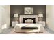 Elegant bedroom with a stylish bed frame, nightstands with lamps, and decorative artwork above the bed at 10857 Rustic Eve Ct, Land O Lakes, FL 34638