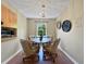 Cozy dining area with a round table, stylish lighting, and a view to the outside at 1125 83Rd N Ave # D, St Petersburg, FL 33702