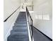 Carpeted staircase with black iron railings, leading to the upper level at 1125 83Rd N Ave # D, St Petersburg, FL 33702