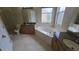 Modern bathroom featuring granite countertops, a glass-enclosed shower, and a soaking tub under a window at 11341 Durham St, Parrish, FL 34219