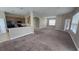 Open-concept living space featuring neutral paint, carpeted floors, and arched entryways to the kitchen at 11341 Durham St, Parrish, FL 34219