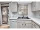 Bright kitchen with white countertops and cabinets, stainless steel sink, and white appliances at 12400 Park Blvd # 417, Seminole, FL 33772