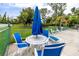 Relaxing poolside seating area with blue chairs and a table, perfect for enjoying the sunshine and socializing outdoors at 12400 Park Blvd # 417, Seminole, FL 33772