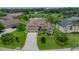 Scenic aerial view of the home with a well-manicured lawn, pond views, and lush landscaping, offering a peaceful setting at 12413 Woodlands Cir, Dade City, FL 33525