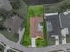 Overhead shot of the property, revealing the well-maintained lawn, enclosed patio, and surrounding landscape, showcasing the property lines at 12413 Woodlands Cir, Dade City, FL 33525