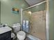 Bathroom featuring walk-in glass shower, decorative towels, and neutral tile at 12413 Woodlands Cir, Dade City, FL 33525