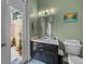 Bathroom with black vanity, toilet, and exit door to patio at 12413 Woodlands Cir, Dade City, FL 33525