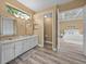 Bathroom with double sinks and an adjacent bedroom beyond the doorway at 12413 Woodlands Cir, Dade City, FL 33525