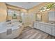 Bathroom with a soaking tub, glass block shower, double vanity, and natural light at 12413 Woodlands Cir, Dade City, FL 33525