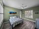 Bedroom with light green walls, ceiling fan, and modern decor at 12413 Woodlands Cir, Dade City, FL 33525