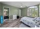 Bedroom with light green walls, wood look floors, and ensuite bathroom at 12413 Woodlands Cir, Dade City, FL 33525