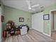 Bedroom with light green walls, ceiling fan, desk, closet, and wood look floors at 12413 Woodlands Cir, Dade City, FL 33525