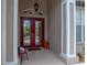 Close up of front entrance featuring a decorative red double-door entry with charming architectural details and potted plants at 12413 Woodlands Cir, Dade City, FL 33525