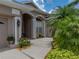 Inviting front entrance with a well-maintained walkway, lush landscaping, and charming architectural details at 12413 Woodlands Cir, Dade City, FL 33525
