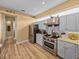 Well-equipped kitchen featuring stainless steel appliances, wood-style floors, and ample counter space at 12413 Woodlands Cir, Dade City, FL 33525
