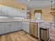 Spacious kitchen with stainless steel dishwasher, modern cabinets, and an open layout to the dining area at 12413 Woodlands Cir, Dade City, FL 33525