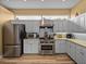 Functional kitchen featuring stainless steel appliances, ample cabinet space, and modern lighting at 12413 Woodlands Cir, Dade City, FL 33525