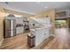 Modern kitchen with white cabinets, stainless steel appliances, and an open layout to the living areas at 12413 Woodlands Cir, Dade City, FL 33525