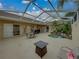 Spacious screened lanai with a relaxing spa, outdoor dining set, and ample seating at 12413 Woodlands Cir, Dade City, FL 33525