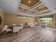 Spacious living room with hardwood floors, a decorative ceiling, and comfortable seating, perfect for relaxation at 12413 Woodlands Cir, Dade City, FL 33525