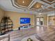 Living room featuring a flat-screen TV, stylish display shelving, and access to the outdoor patio at 12413 Woodlands Cir, Dade City, FL 33525