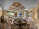 Open-concept living and dining area showcasing a modern ceiling, comfortable seating, and a peaceful outdoor view at 12413 Woodlands Cir, Dade City, FL 33525