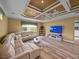 Open living room featuring a modern ceiling design, large sectional sofa, and a view of the outdoor fountain at 12413 Woodlands Cir, Dade City, FL 33525